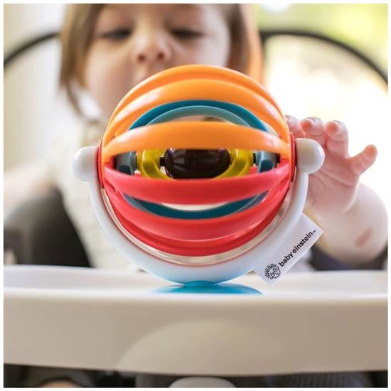 Baby Einstein sticky spinner met rode, oranje, blauwe en gele ringen, op zuignap, met baby op de achtergrond.