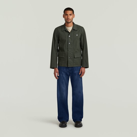 Man met donkergroen G-Star jack, beige T-shirt en jeans.