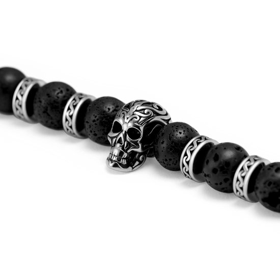 Armband met zwarte lavasteentjes en een zilverkleurige schedelbedel met tribal-patroon.