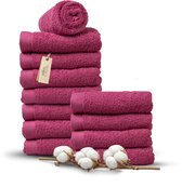 Stapel fuchsia handdoeken met een opgerolde handdoek bovenop en katoentakken ernaast.