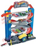 Blauwe Hot Wheels Stunt Garage speelgoedauto garage met meerdere verdiepingen, vol met diverse Hot Wheels auto's en oranje glijbanen.