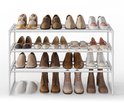 Wit schoenenrek met drie lagen, gevuld met diverse schoenen, inclusief sneakers en laarsjes.