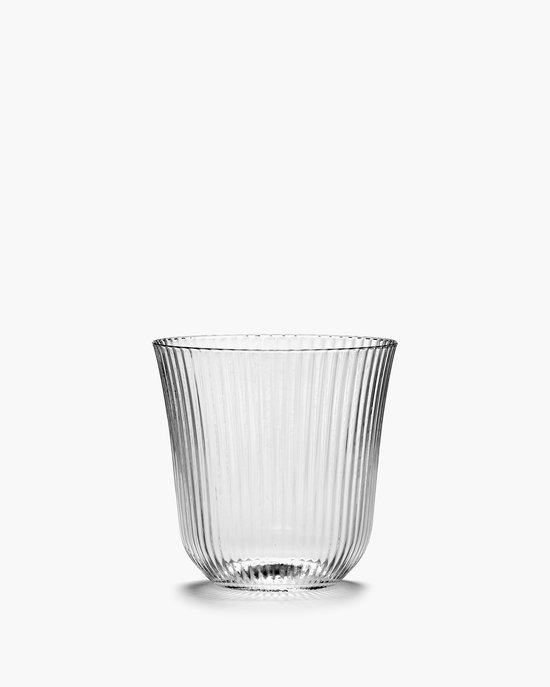 Een geribbeld, transparant waterglas op een witte achtergrond.