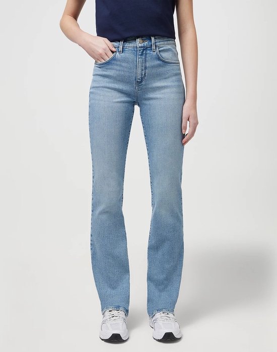 Model in lichtblauwe Wrangler bootcut jeans, zichtbaar vanaf de voorkant. De jeans hebben een kenmerkend 'W' logo op de achterzakken.