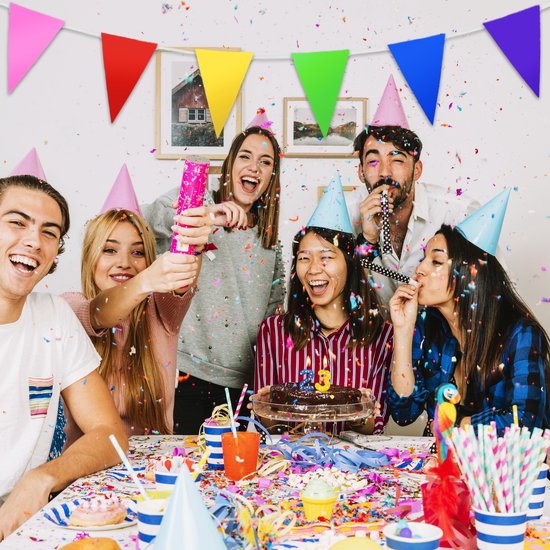Un groupe d'amis célèbre un anniversaire avec un gâteau, des confettis et des fanions multicolores.
