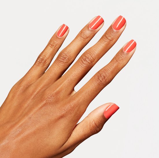 Een hand met koraalrode nagels.