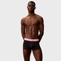 Man in zwarte Calvin Klein boxershorts met roze tailleband.