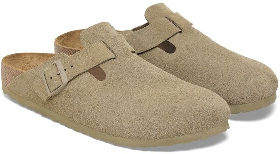 Paar beige suède Birkenstock Boston slippers met verstelbare gesp, bekeken vanaf de zijkant.