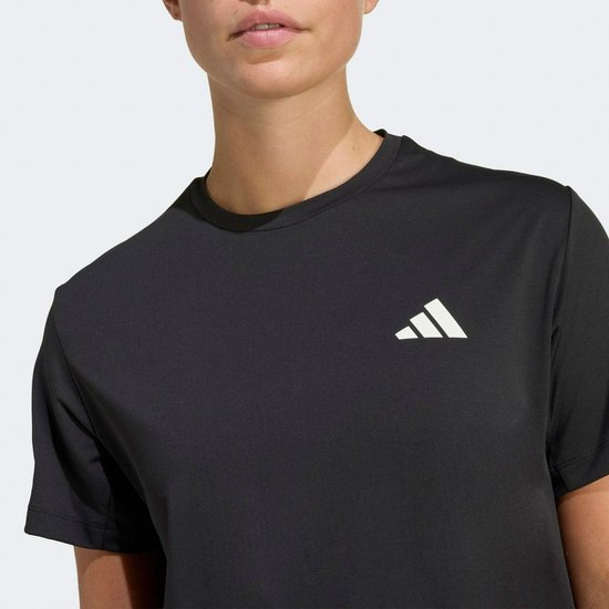 Close-up van een zwart Adidas sportshirt met een Adidas logo op de borst.
