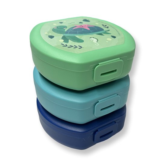 Stapel van drie snackboxen: boven groen met schildpad, midden blauw, onder donkerblauw.