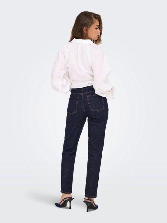 Model in een rechtvallende donkerblauwe jeans met hoge taille, van achteren gezien.