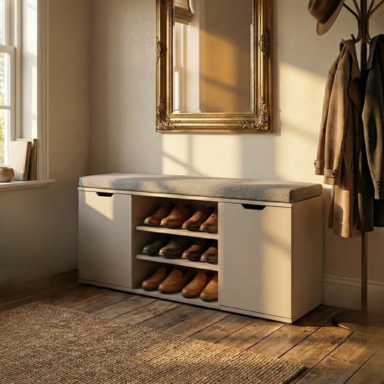 Licht beige schoenenkast met zitbank, 3 open vakken en 2 deuren. Goudkleurige spiegel erboven.