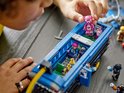 Des enfants construisent le LEGO Fortnite Battle Bus, avec une figurine d'ours rose dans le bus.