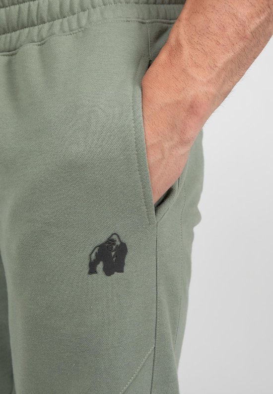 Sluiting van groene joggingbroek met zwart Gorilla Wear logo op de linker broekzak.