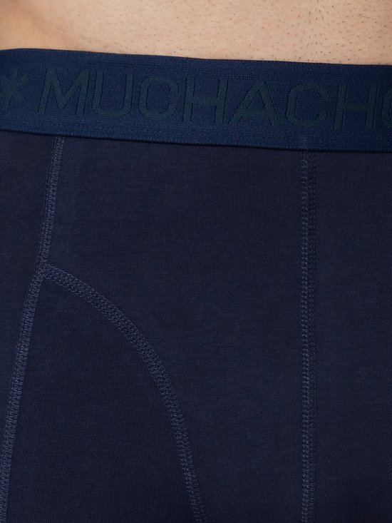Detail van een marineblauwe boxslip met 'MUCHACHOMALO' logo-band en stiksels.