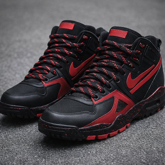 Zwarte Nike mid-top sneakers met rode accenten, veters en Nike logo.