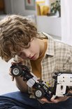 Jongen met LEGO Technic truckonderstel en wielen.