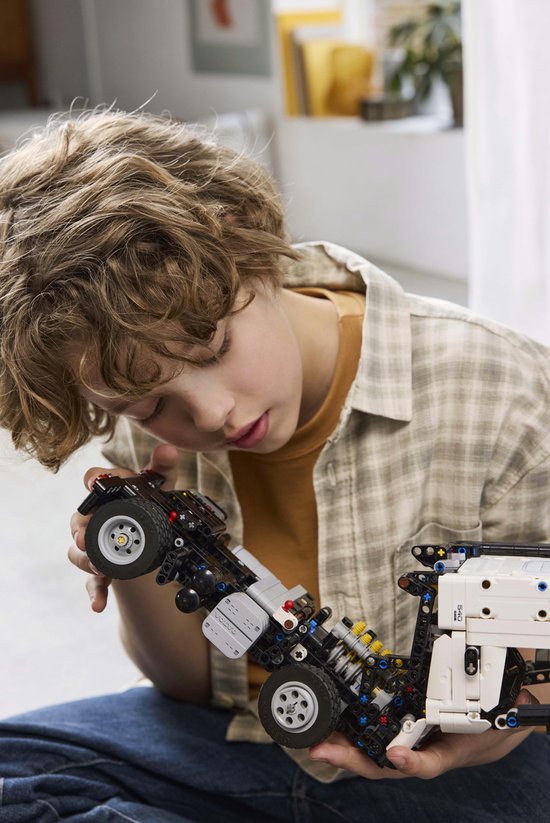 Jongen met LEGO Technic truckonderstel en wielen.