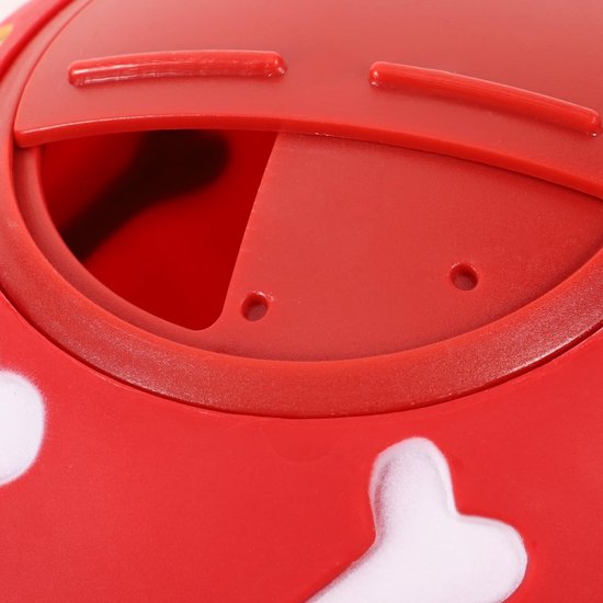 Close-up van een rode speelbal met opening en witte bot-afdrukken.