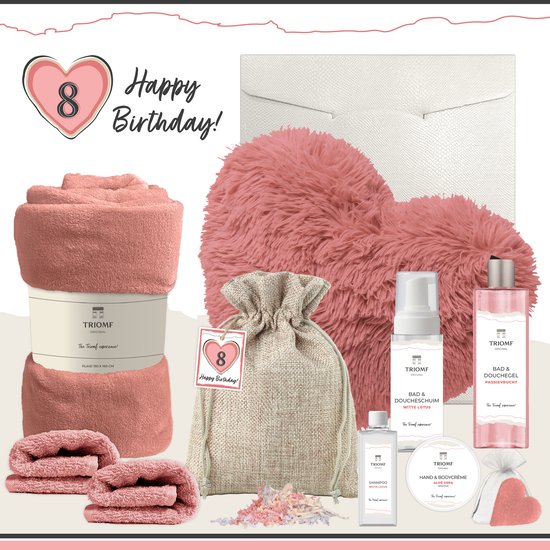 Een roze cadeaupakket met een plaid, kussen, douchegel, shampoo, handcrème, en een zakje met watjes.