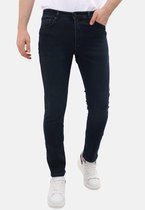 Donkerblauwe slim fit jeans met rechte pijpen, gedragen door een model met de hand in de zak.