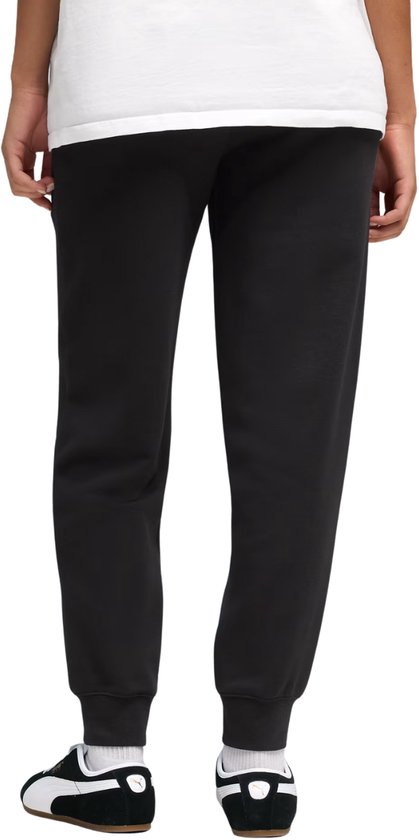 Achterkant van model in zwarte Puma joggingbroek, met elastische tailleband.