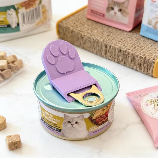 Paarse pootvormige blikopener op een blik kattenvoer.