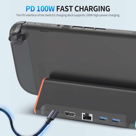 Een Switch 2 is aangesloten op de zwarte dock met oranje accenten. Een kabel is aangesloten op de PD-interface voor 100W snelladen.
