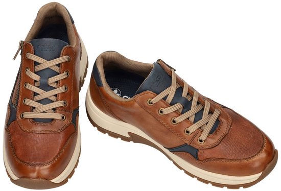 Paar bruine sneakers met rits, veters en donkerblauwe accenten.