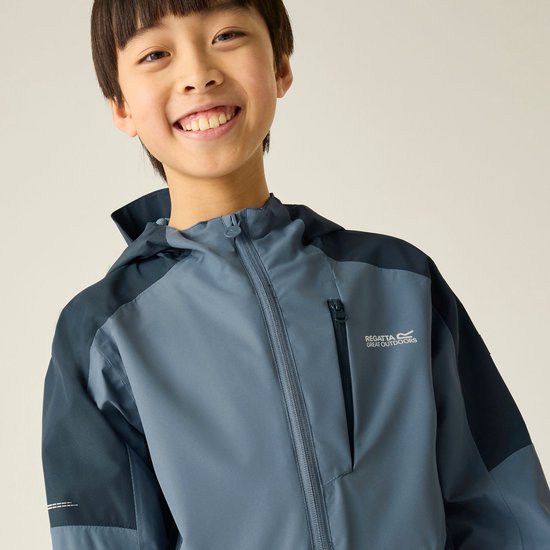 Jongen in een blauwe Regatta outdoorjas met donkerblauwe accenten en capuchon.