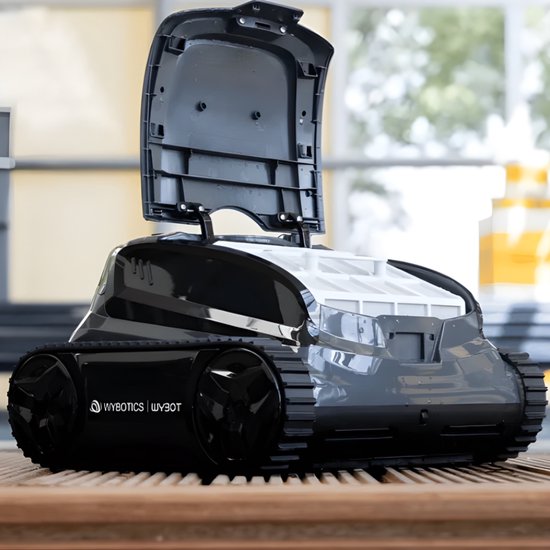 Zwarte Wybot zwembadrobot met open deksel en wit filtercompartiment, staand op een houten ondergrond.