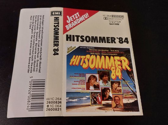 Hoes van de cassette 'HITsommer '84' met foto's van artiesten en strandlandschap.