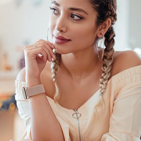 Model met een lichtbruin gevlochten Apple Watch bandje om de pols.