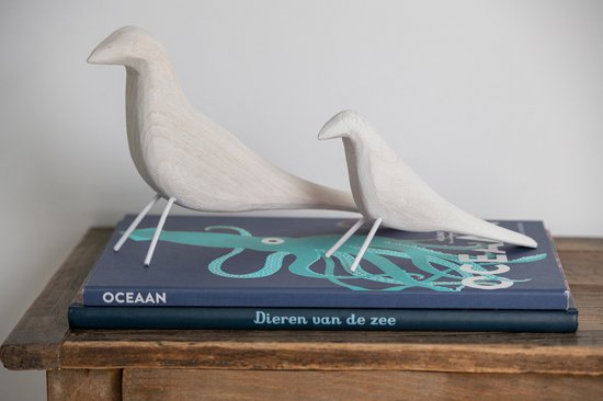 Ensemble de deux figurines d'oiseaux en bois blanc sur des livres imprimés d'une pieuvre. 'OCEAN' et 'Dieren van de zee' sur les dos.