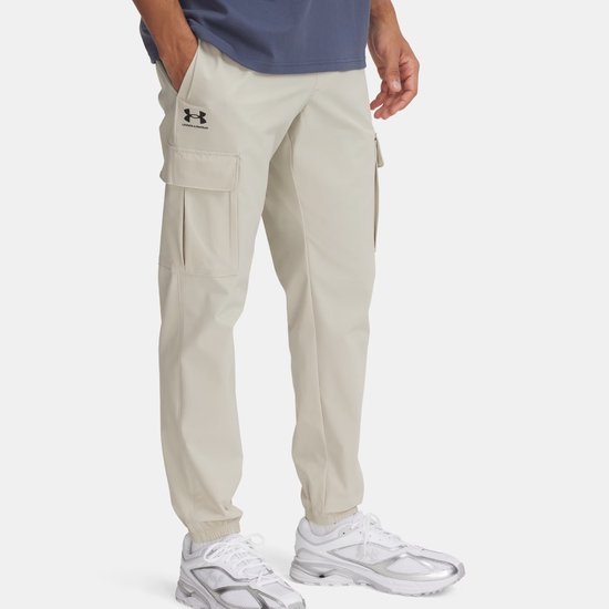 Beige cargo trainingsbroek met Under Armour logo, gedragen door een man.