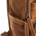 Detailopname van een cognac leren rugzak met rits en leren label.