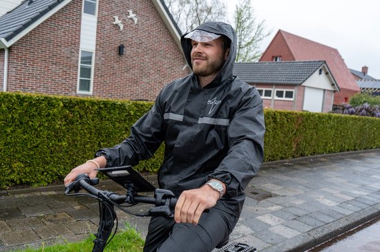 Man op een fiets in de regen, draagt een zwarte regenjas met capuchon en reflecterende strepen. De jas heeft het "VOLTANO" logo.