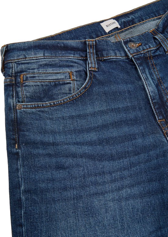 Detail van de voorkant van een blauwe Mustang jeans met oranje stiksels en een klein muntzakje.