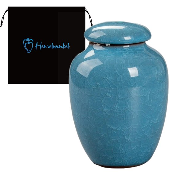 Lichtblauwe keramische urn met een craquelé-afwerking, naast een zwarte bewaarzak met 'Hemelwinkel'-logo.