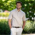 Homme avec un polo beige, un pantalon beige et une ceinture marron foncé avec une boucle carrée.