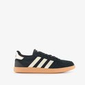 Zwarte Adidas sneaker met gouden strepen en gummi zool, zijaanzicht.