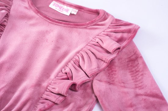 Nekdetail van een roze fluwelen jurk met ruches.