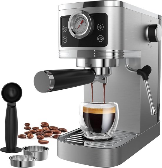 Zilverkleurige espressomachine met een glazen mok met espresso. Naast de machine liggen koffiebonen, een schepje en twee kleine metalen bakjes.