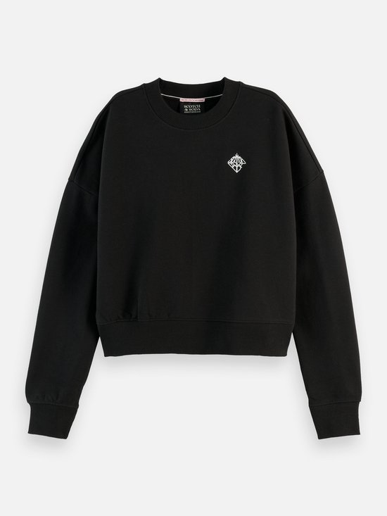 Zwarte sweater met lange mouwen en een ronde hals. Op de borst is een zilverkleurig geborduurd logo te zien. De zoom en mouwen zijn afgewerkt met elastische boorden. Scotch & Soda label in de nek.
