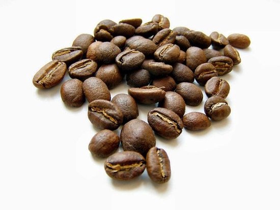 Een hoopje geroosterde koffiebonen met een duidelijke gleuf in het midden.