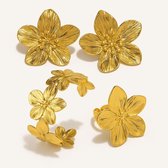 Gouden bloemoorbellen, een bloemarmband en een bloemring.