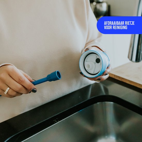 Gros plan sur une personne dévissant la paille bleue de la gourde Kambukka pour le nettoyage.