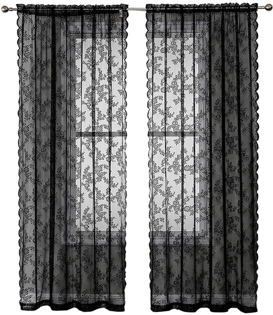 Twee zwarte kantgordijnen met bloemenpatroon, hangend voor een raam, geïsoleerd.