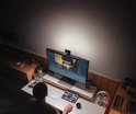 Man werkt aan een computer met BenQ ScreenBar Halo 2, verlichting is gericht op het bureau.