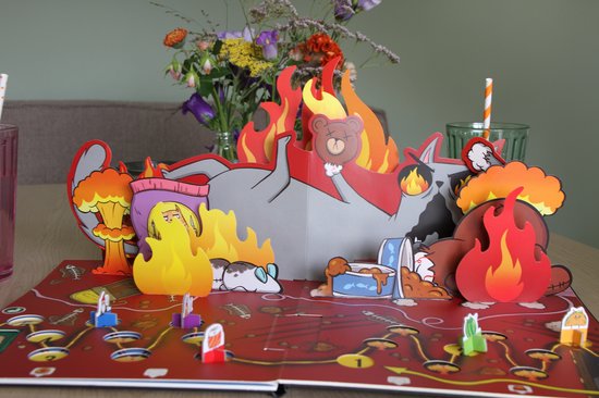 Een 3D pop-up van het Exploding Kittens bordspel met een grote kat omringd door vlammen, teddyberen, snacks en spelerspionnen.